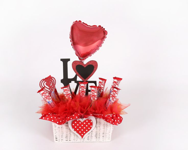 a valentine's day gift basket filled with chocolates and balloons