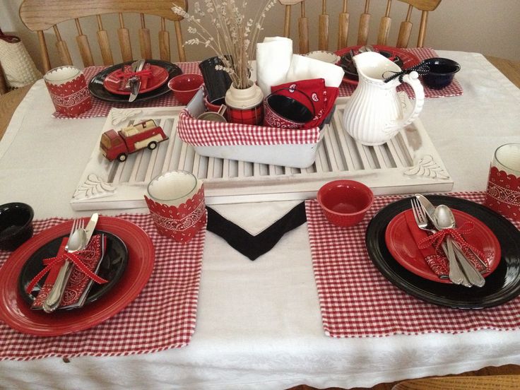 the table is set with red and black dishes