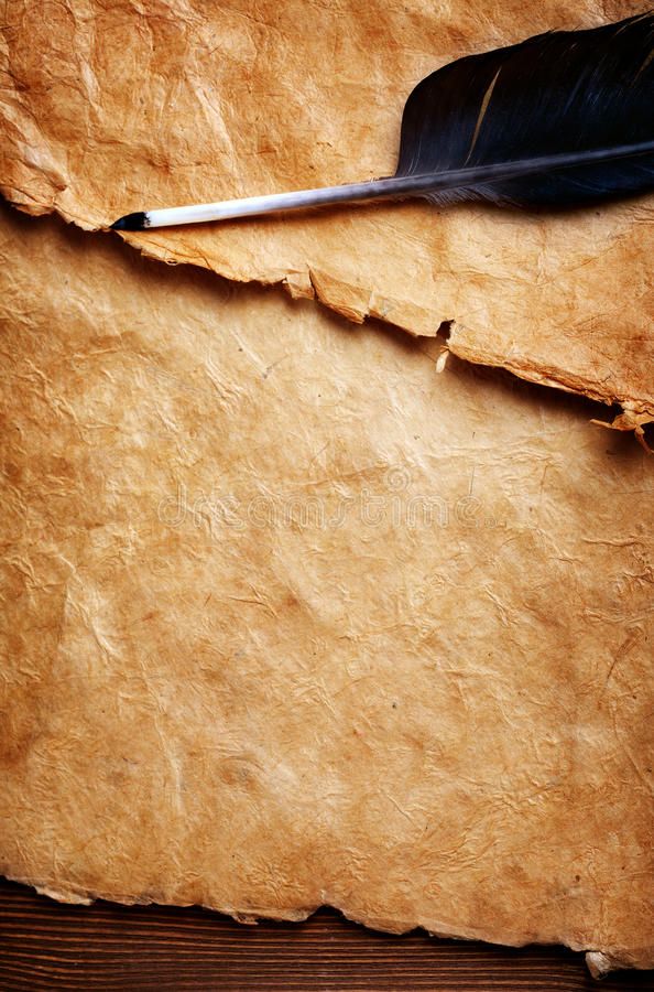 an old piece of paper with a feather quill resting on it, next to a pen