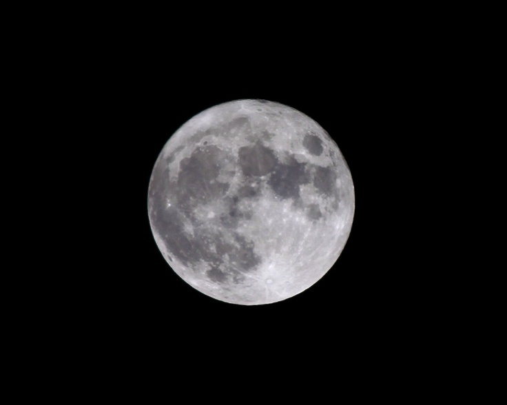 the full moon is seen in the dark sky