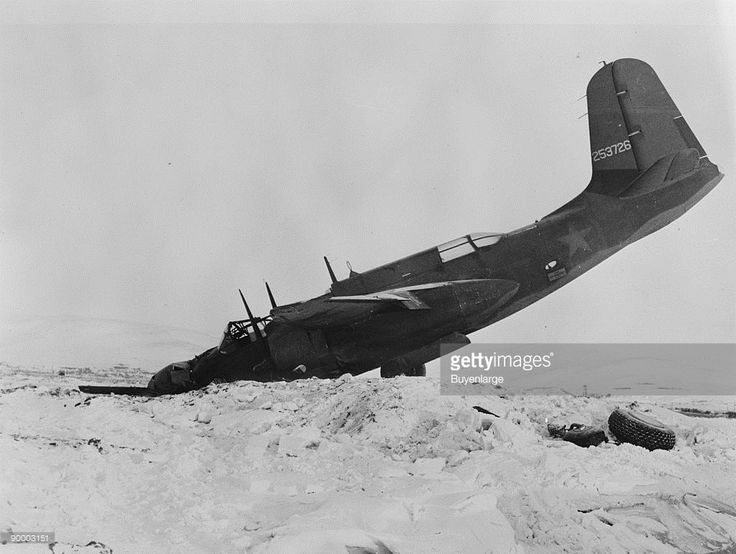 an old airplane sitting in the snow on top of a pile of snow covered ground