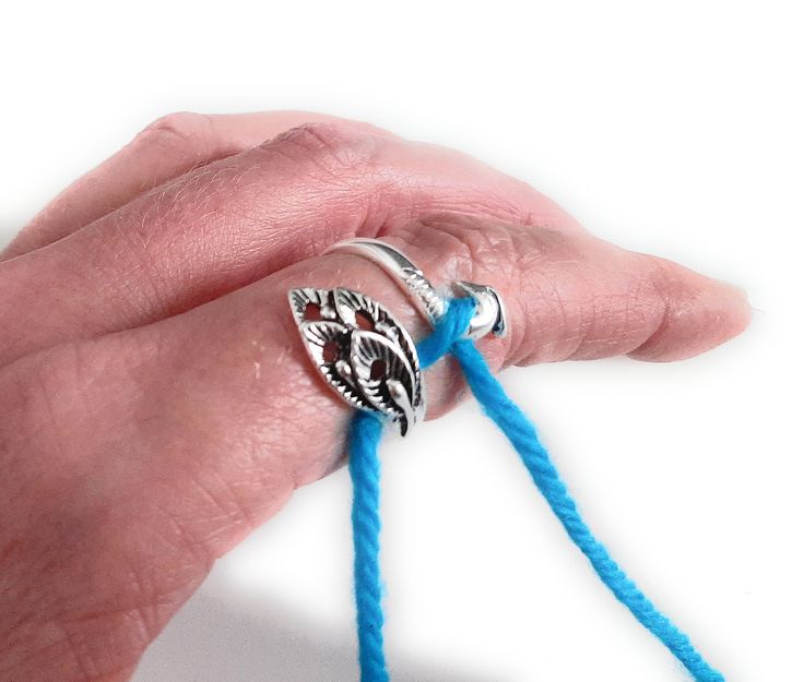 a woman's hand holding a blue string with an owl ring on top of it