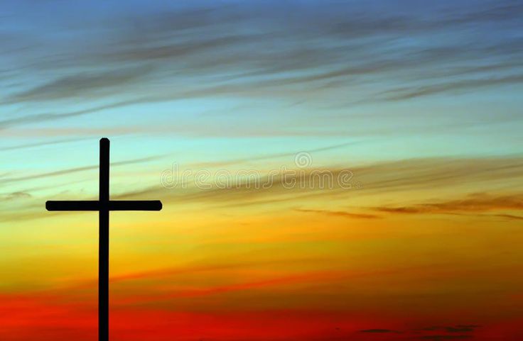 a cross on top of a hill at sunset