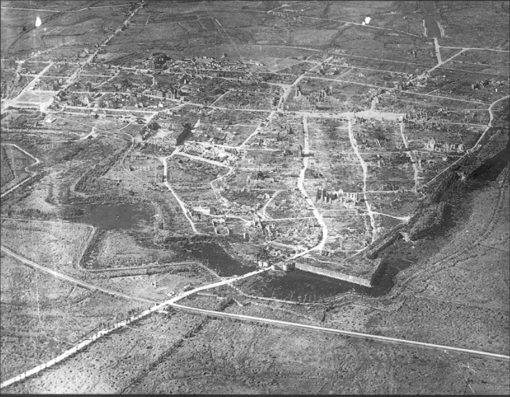 an old black and white photo of a city in the middle of nowhere on land