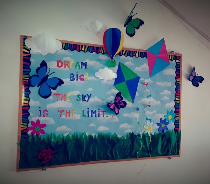 a bulletin board with butterflies and kites on the wall next to it that says dream big, the sky is the limit