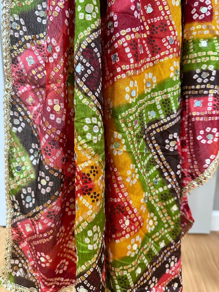 Experience the beauty of traditional Phulkari style with our Multicolor Dupatta. Made with a soft and luxurious silk finish, this dupatta features real mirror accents and stunning designs. Its heavy-weight construction makes it perfect for special occasions like Navaratri. Elevate your wardrobe with this must-have accessory. Approx 2.5 meters length Multicolor Zari Work Sharara For Diwali, Multicolor Chinon Traditional Wear With Zari Work, Multicolor Chanderi Saree With Sheer Dupatta, Red Art Silk Dupatta With Mirror Work, Silk Multicolor Anarkali Set With Sheer Dupatta, Traditional Gota Work Dupatta For Eid, Eid Banarasi Silk Dupatta With Bandhani Print, Multicolor Traditional Wear In Chinon, Sheer Katan Silk Dupatta For Diwali