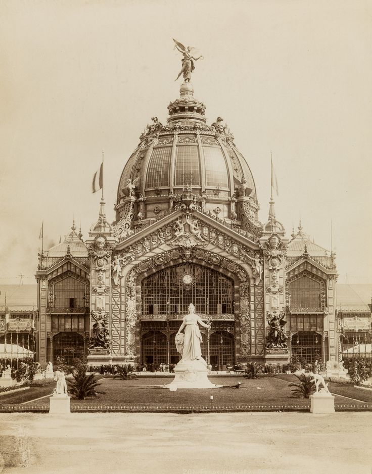 an old photo of a building with a statue in front