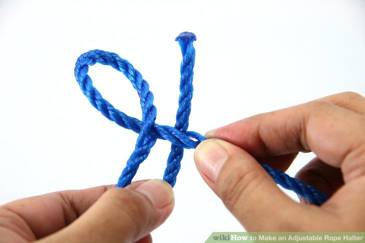 two hands holding blue string with one knot in the middle