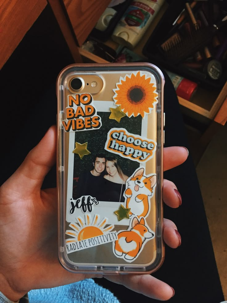 a person holding up a clear case with pictures on it and the words, no bad vibes choose happy selfie