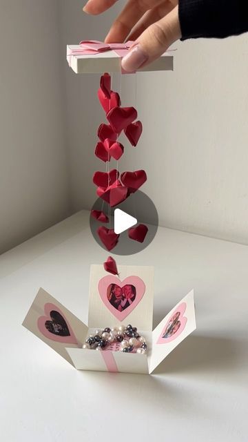 someone is placing hearts on top of the card holder to make it look like they are falling