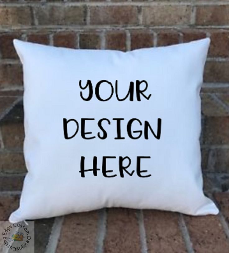 a white pillow with the words your design here on it sitting against a brick wall