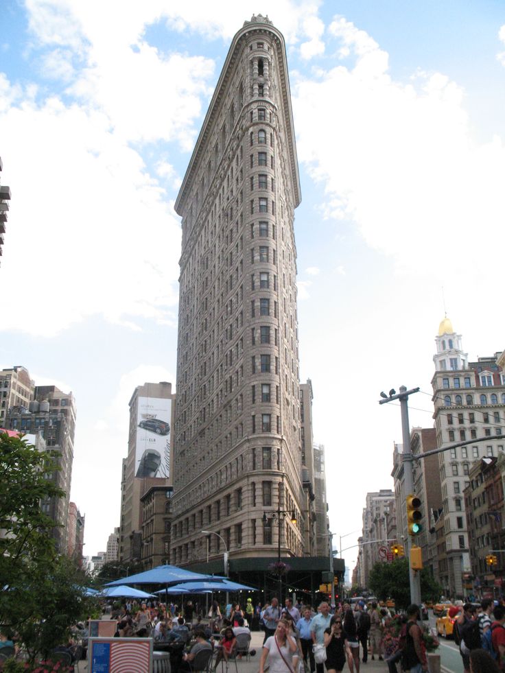 people are walking around in front of a tall building