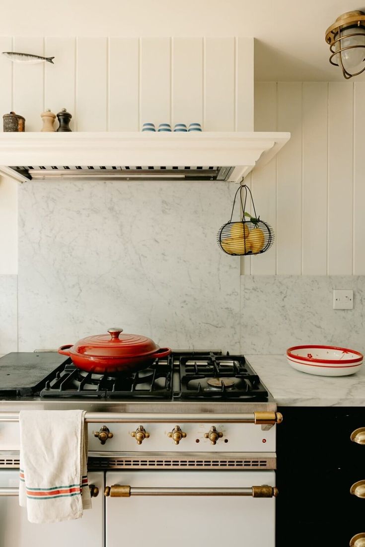 a white stove top oven sitting inside of a kitchen next to a wall mounted oven