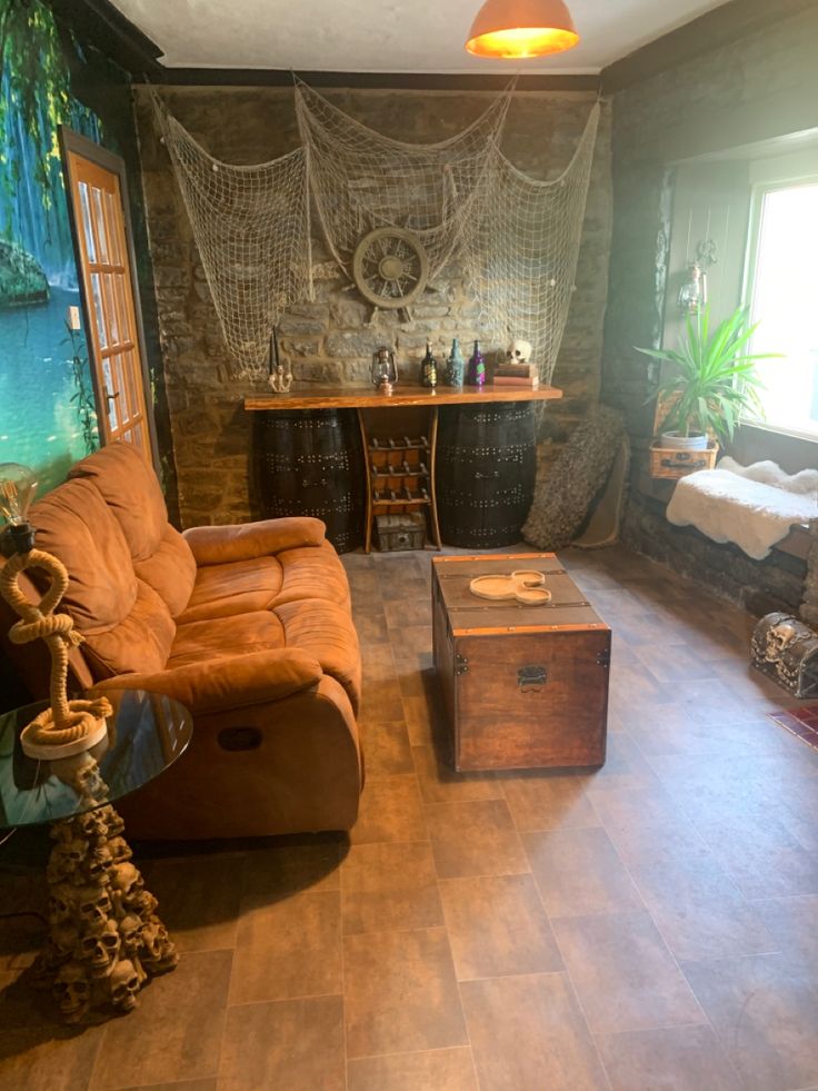 a living room filled with furniture next to a window covered in curtains and netted wall hangings