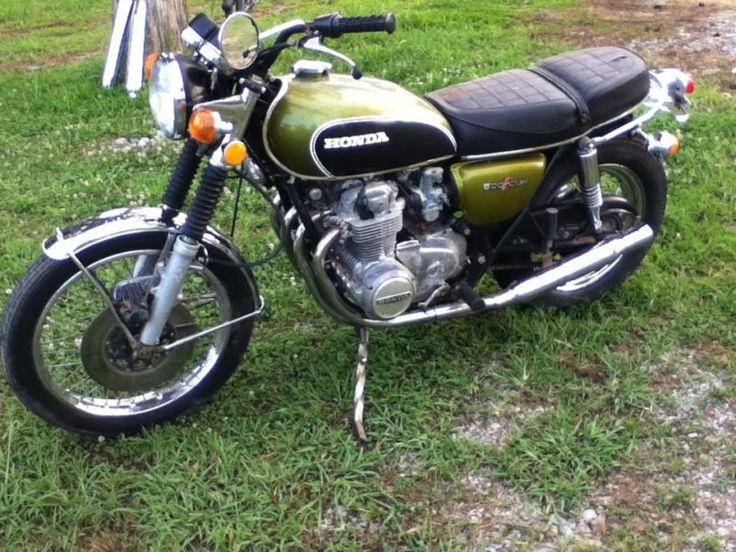 a green motorcycle parked on top of a lush green field