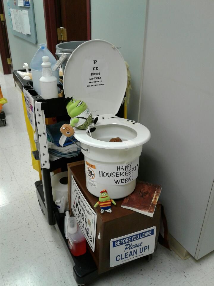 a white toilet sitting on top of a pile of cleaning supplies next to a refrigerator