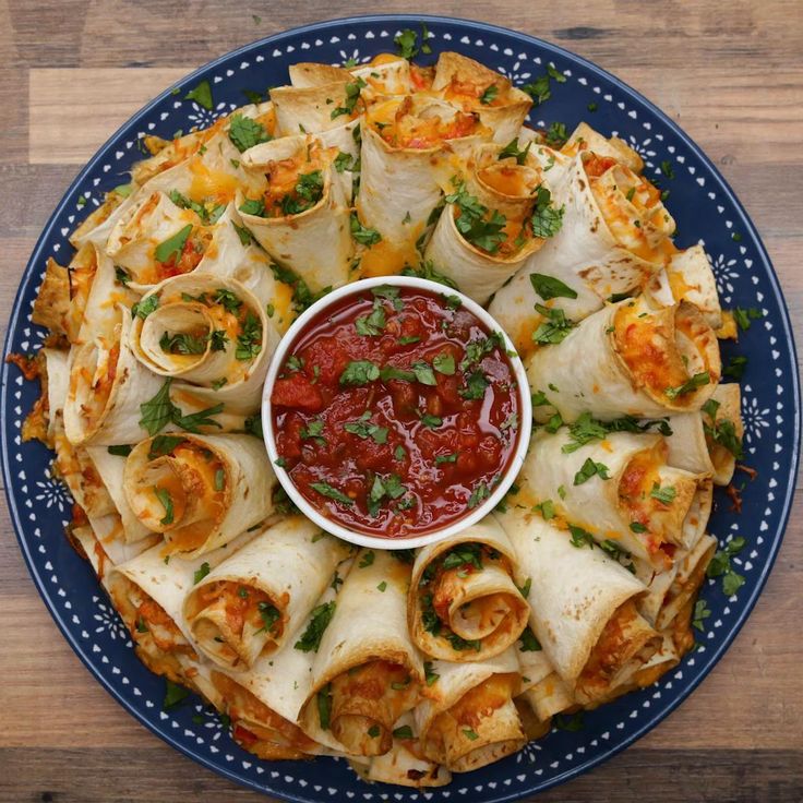 a blue plate topped with tortillas covered in sauce