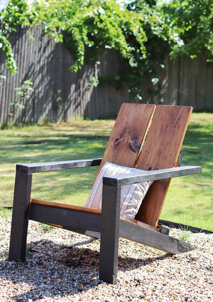 a wooden chair sitting on top of a gravel field