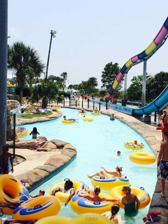 people are in the water at an outdoor swimming pool with large floats and slides