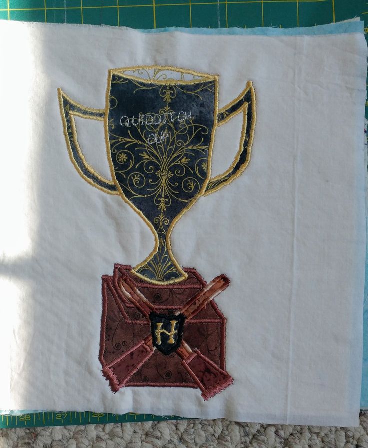 a close up of a piece of cloth with a cup on it and a ribbon