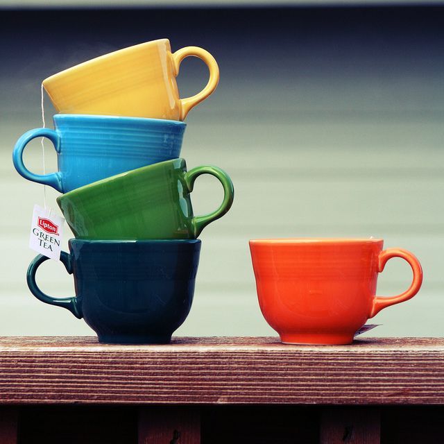 four cups stacked on top of each other with price tags in front of the mugs