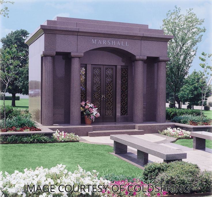 a memorial with benches and flowers in the foreground