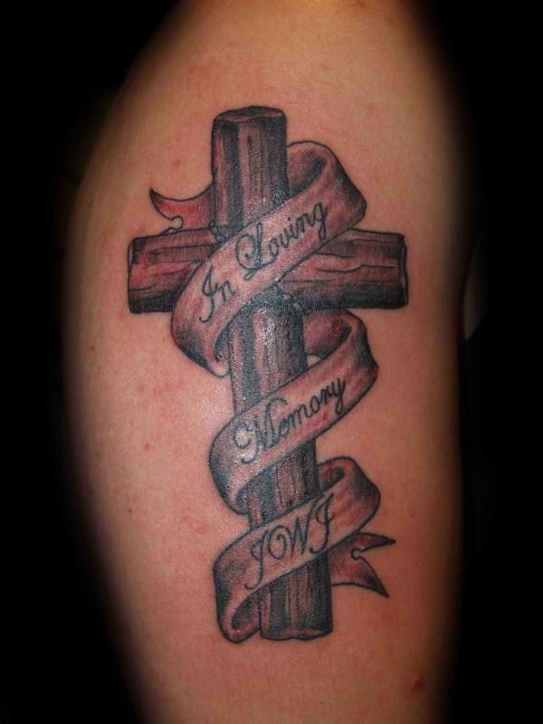 a cross tattoo with ribbon around it