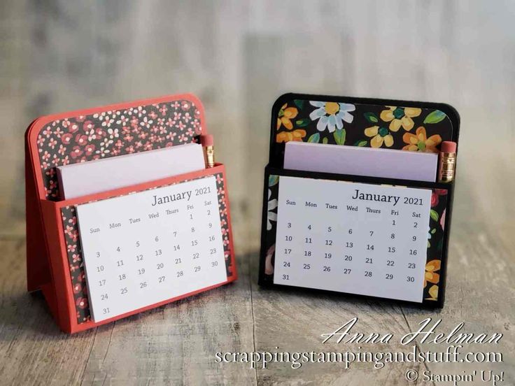 two small desk calendars sitting next to each other on top of a wooden table