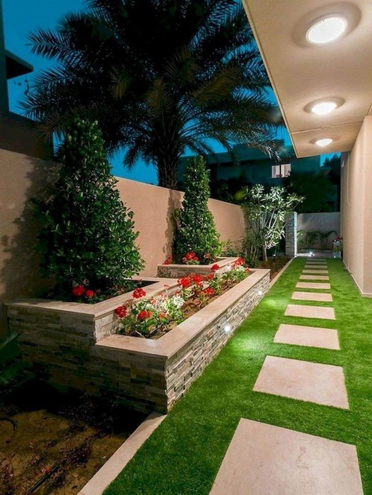 an outdoor garden with artificial grass and flowers in the planter boxes on either side