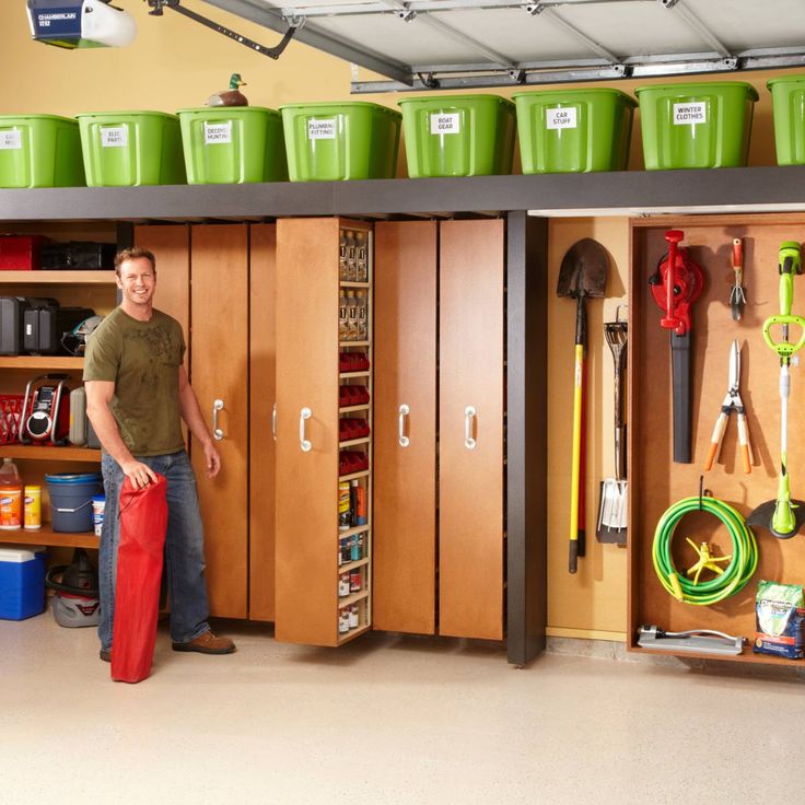 a man standing in front of some lockers with green bins on the top