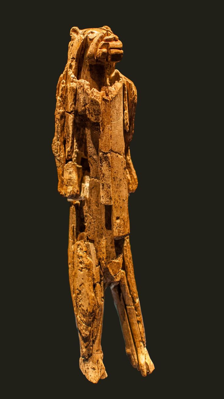 a wooden statue is shown against a black background