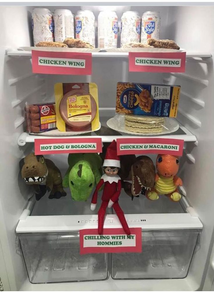 an elf is standing in the refrigerator with food on shelves and signs that read chicken wing, hot dog & hamburgers