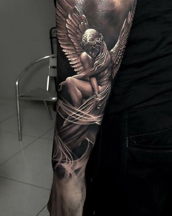 a man's arm with an angel tattoo on it