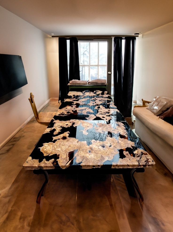 a long table with black and white designs on it in front of a large window