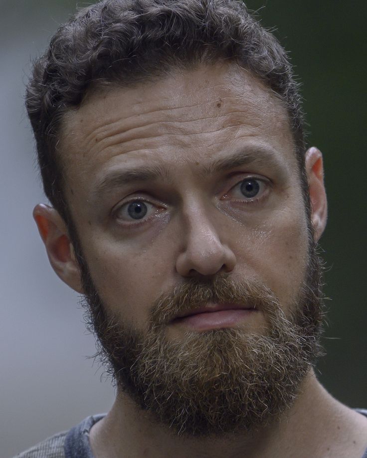 a close up of a man with a beard and blue eyes looking at the camera