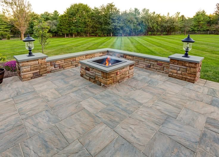 an outdoor fire pit surrounded by stone walls