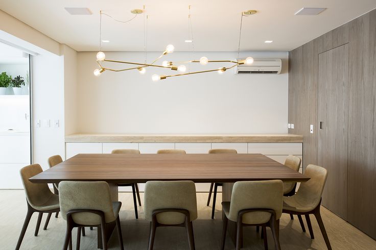 a large wooden table surrounded by chairs in a room with white walls and wood flooring