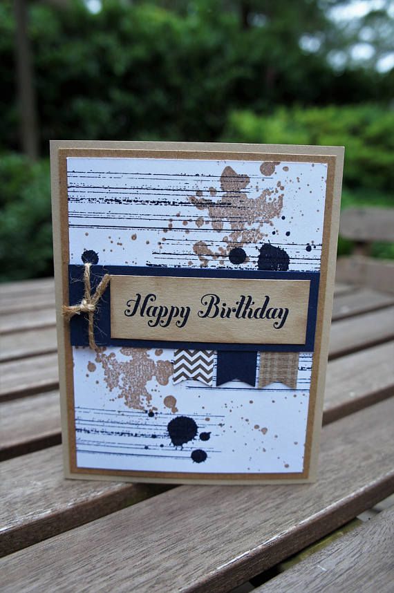 a happy birthday card sitting on top of a wooden table with trees in the background