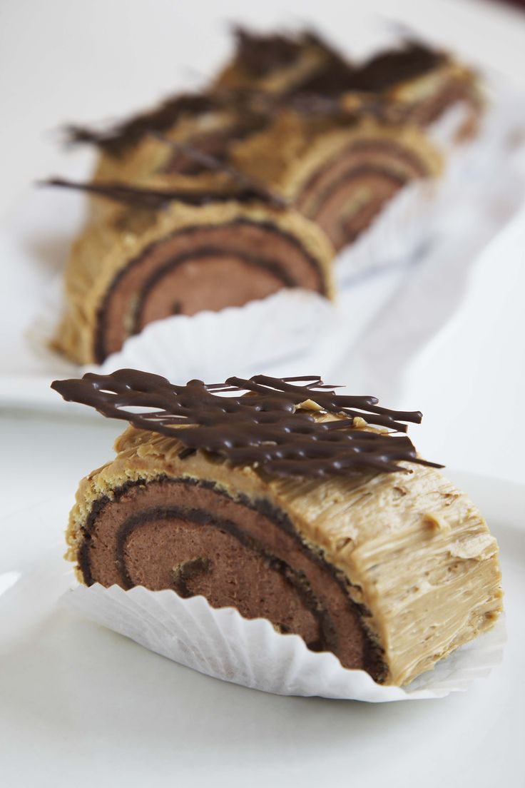 two pieces of chocolate pastry sitting on top of a white plate