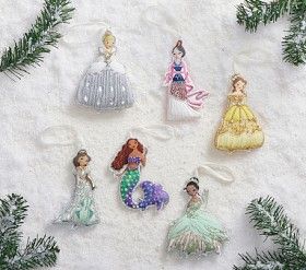 christmas ornaments are arranged in the shape of mermaids and princesses on snow covered ground