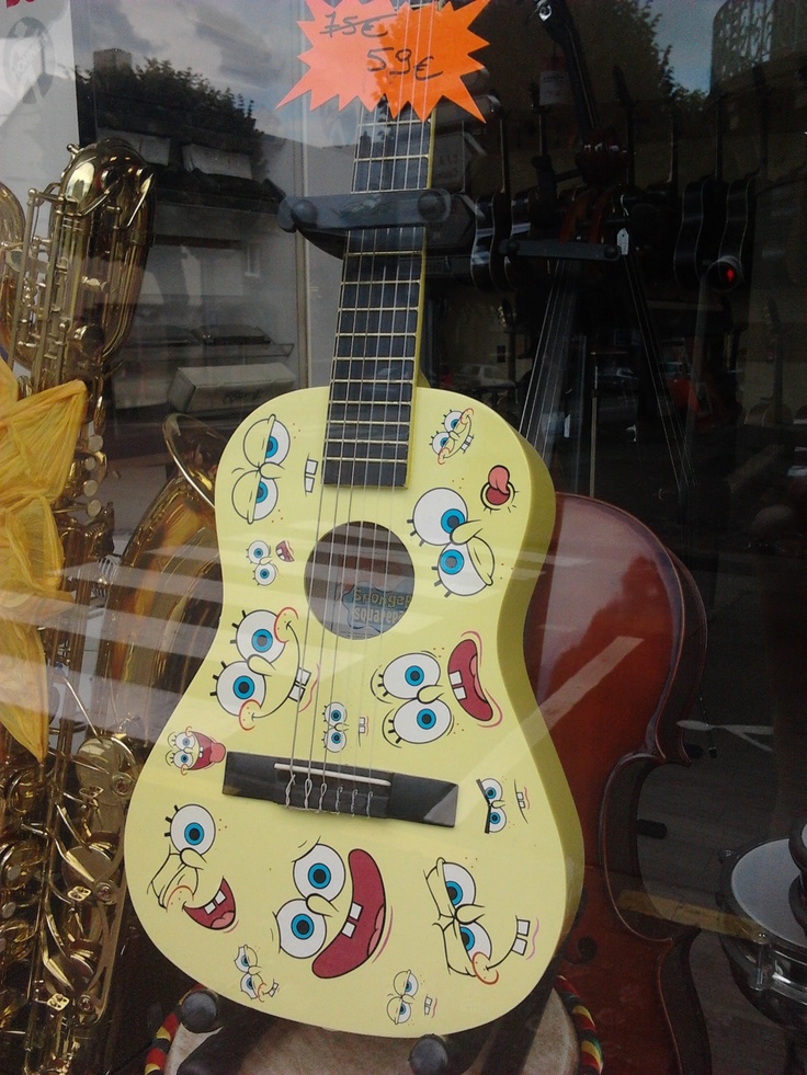 a yellow ukulele sitting on display in a store window