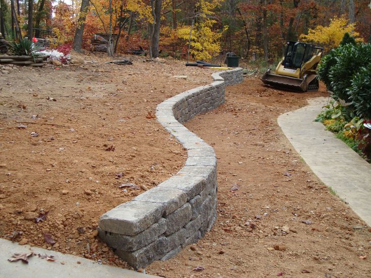 a stone wall in the middle of a yard