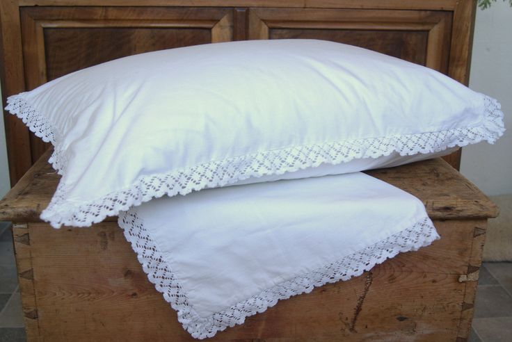 two white pillows on top of a wooden box