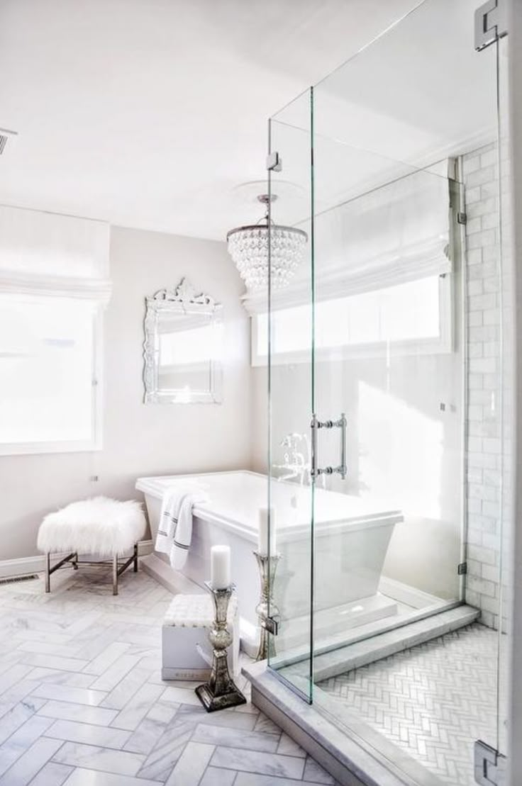 a white bathroom with a glass shower door