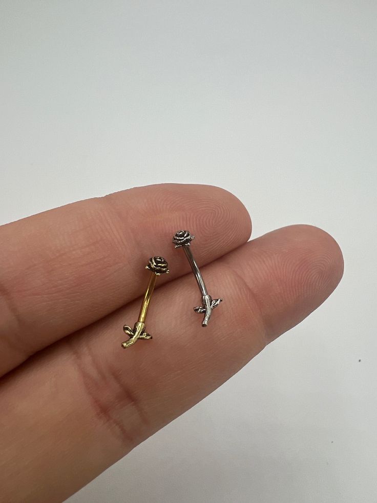 -316L Surgical Steel Barbell -Available in 6mm and 8mm Long -Burnished Gold -Burnished Silver  -Bar Thickness is 16 Gauge (1.2mm) -Rose Flower Design 4mm x 4mm If you have any questions about sizing or length, please feel free to contact us Item 17-18 Cute Eyebrow Piercing Jewelry, Curved Barbell Jewelry, Bridge Piercing Jewelry, Eyebrow Piercing Jewelry, Bridge Piercing, Piercing Bar, Eyebrow Jewelry, Piercing Inspo, Face Piercings