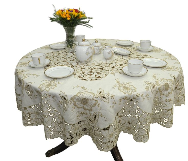 a white table topped with plates and cups next to a vase filled with yellow flowers