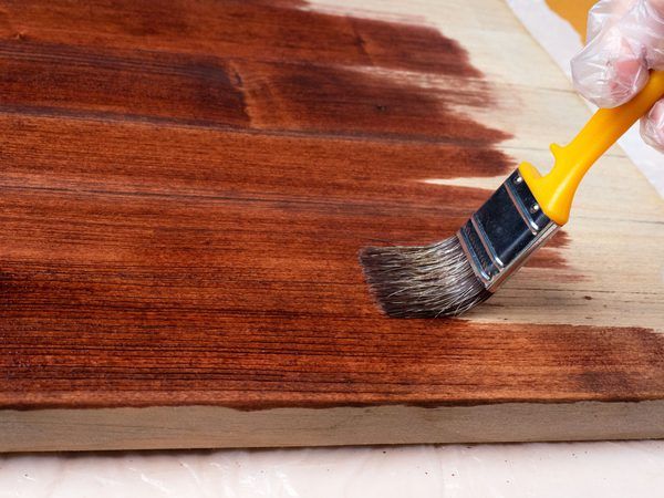 someone using a brush to paint wood