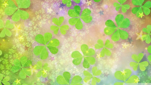 four leaf clovers are flying in the air with stars and sparkles around them