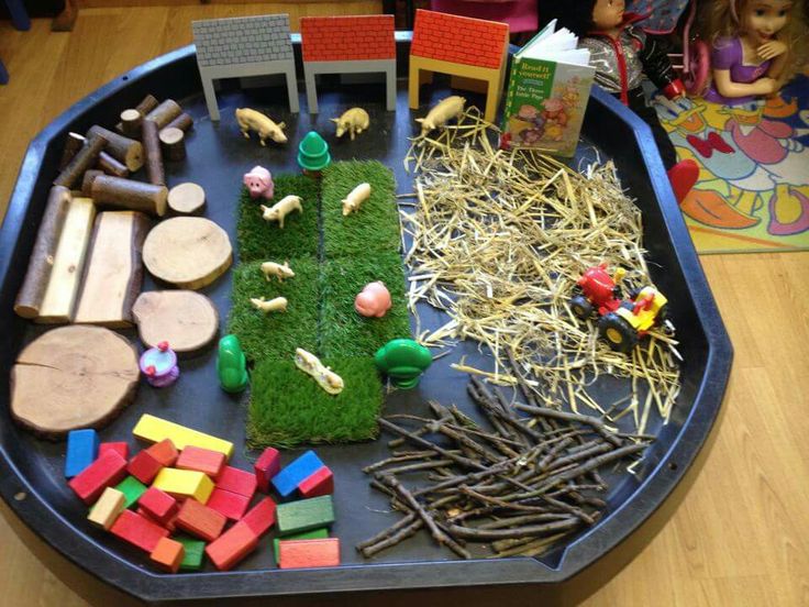 a play tray filled with toys and grass