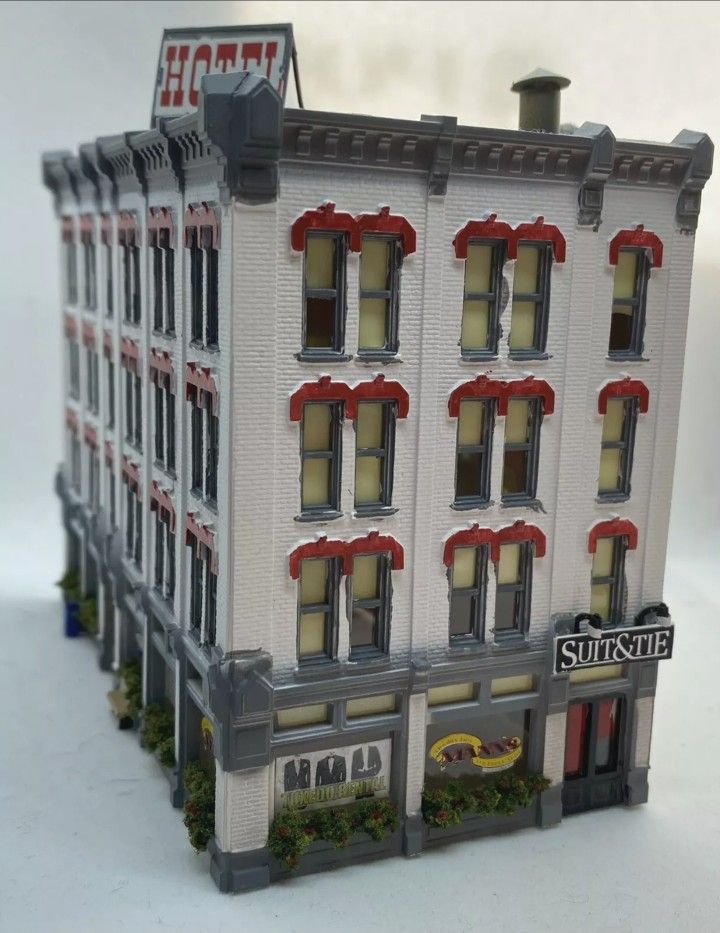 a toy model of a building with red and white awnings on the windows